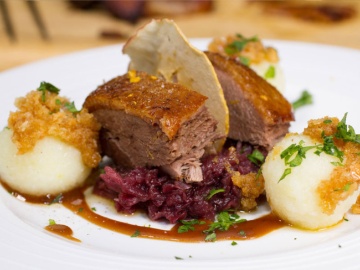 Gans lecker oder ganze Ente Eine ganze Gans oder Ente am Tisch für Sie tranchiert