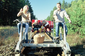 Familie auf Draisinentour in der Natur